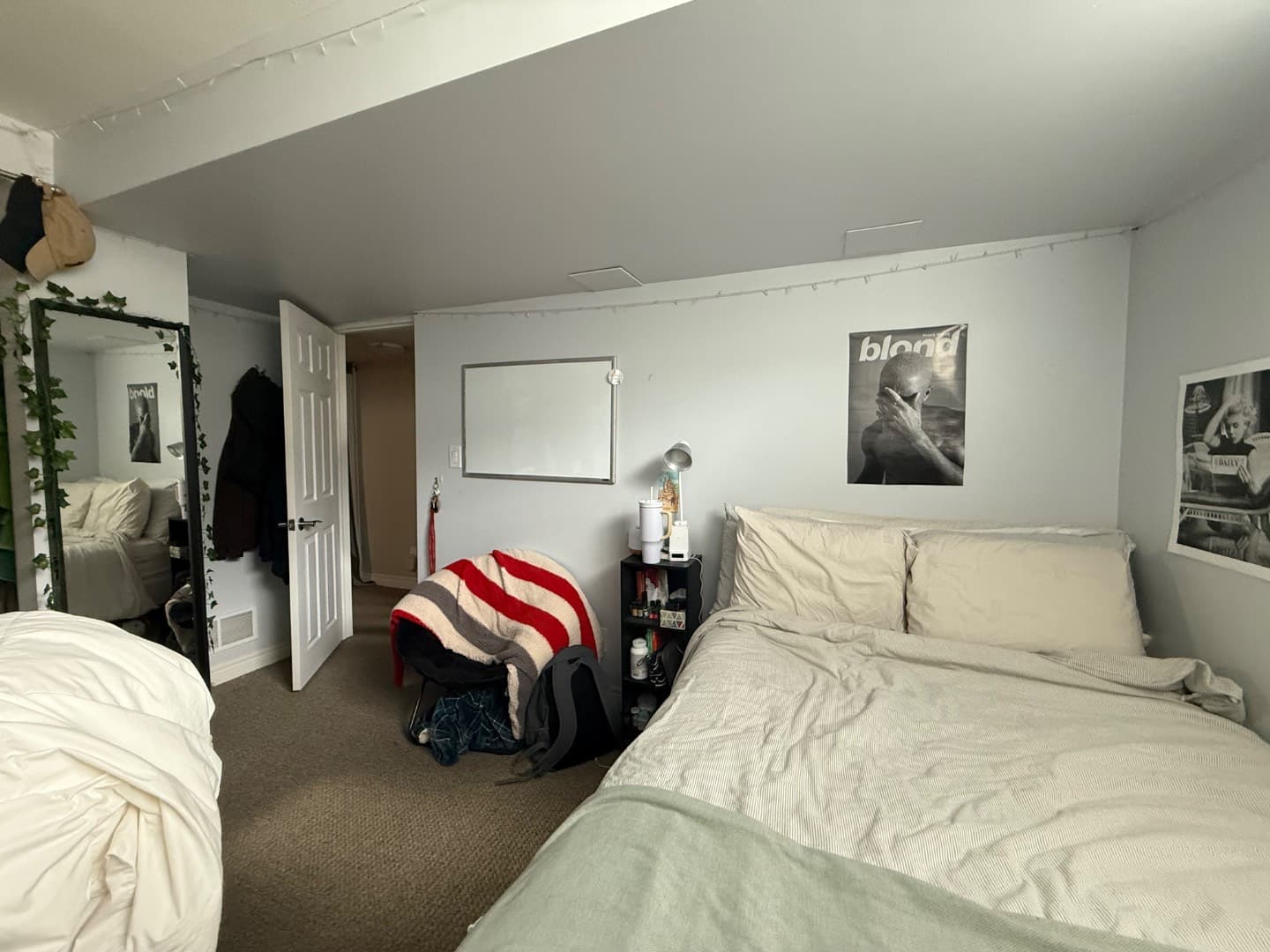 Large basement bedroom with two beds and mirror