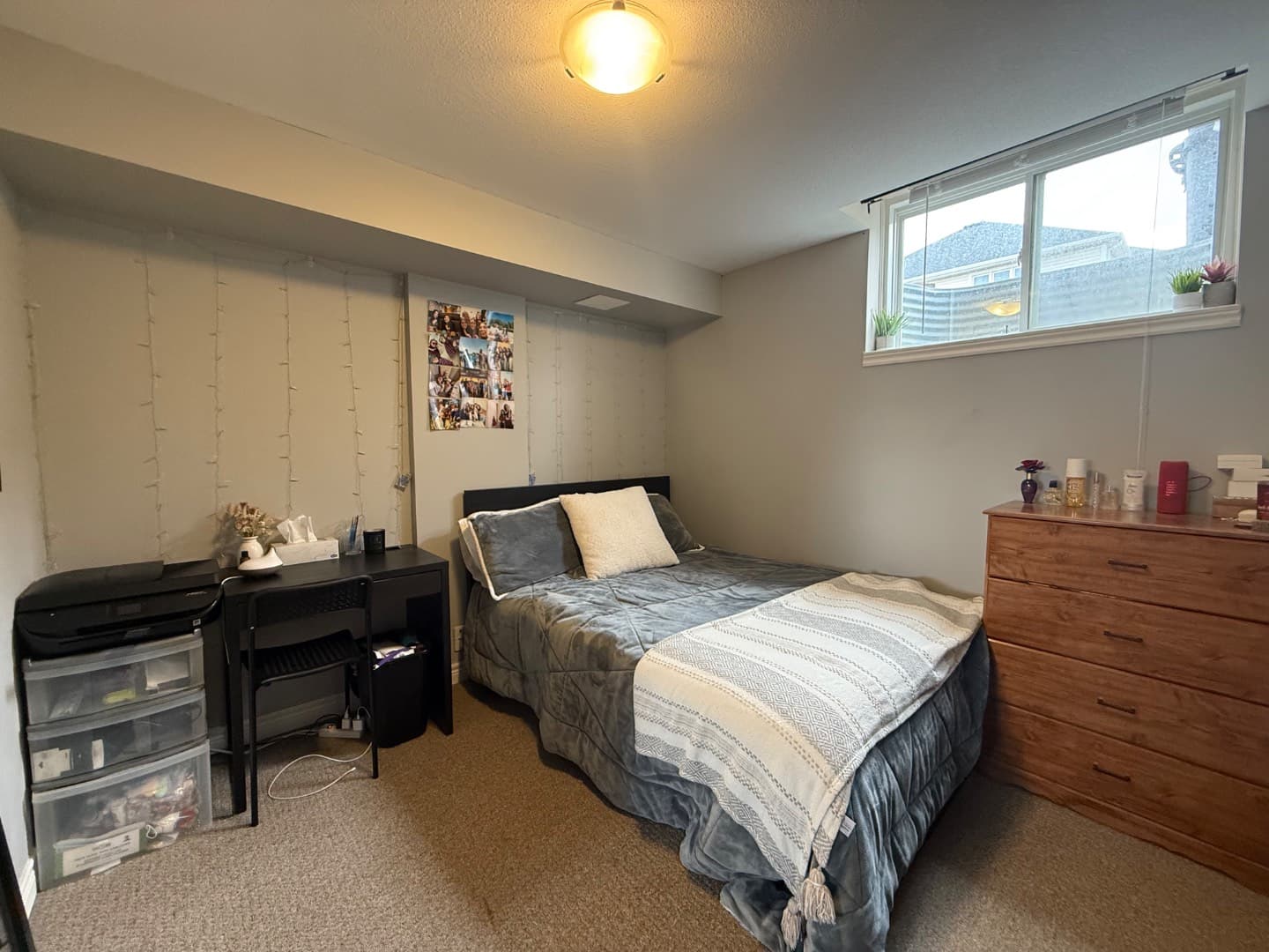 Basement bedroom with egress window, desk and dresser