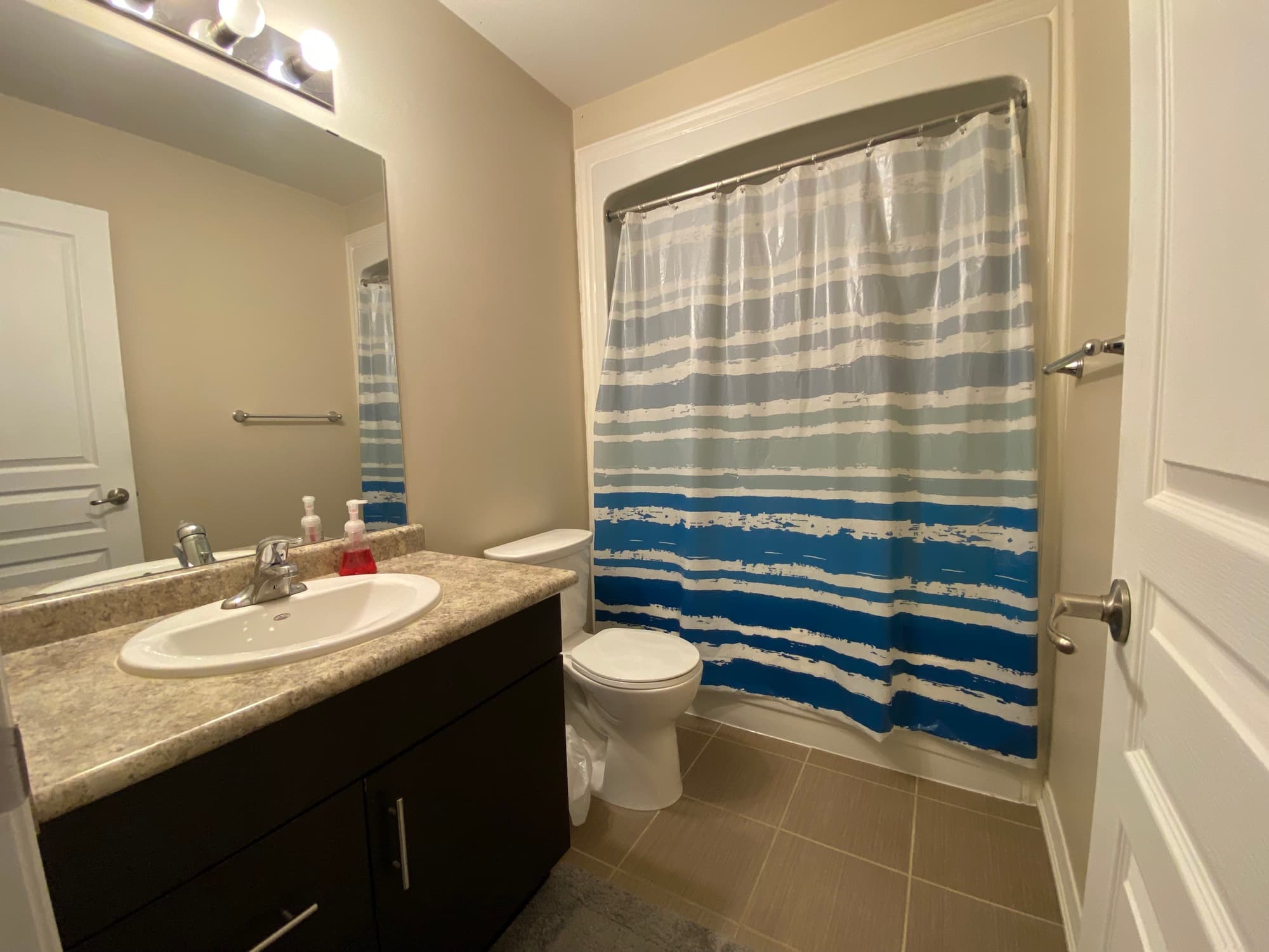 Bathroom with tub-shower combination and vanity