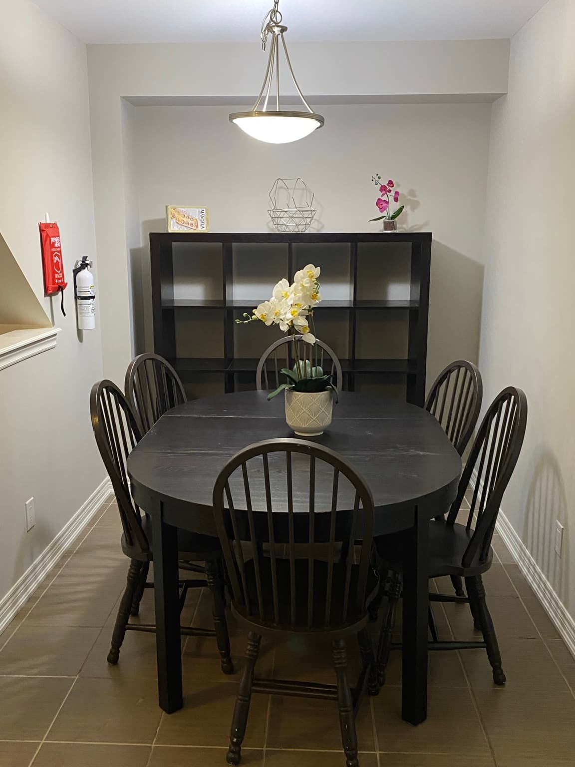 Dining room with a large table, six chairs and a display shelf