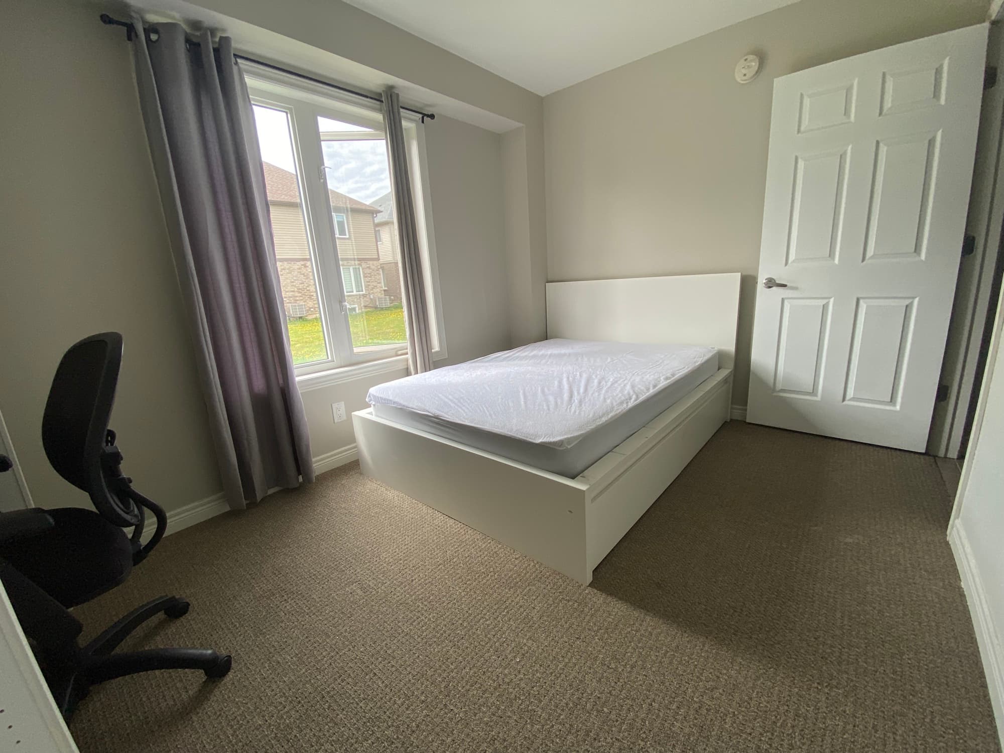 Main-floor bedroom seen from the doorway, with window and desk