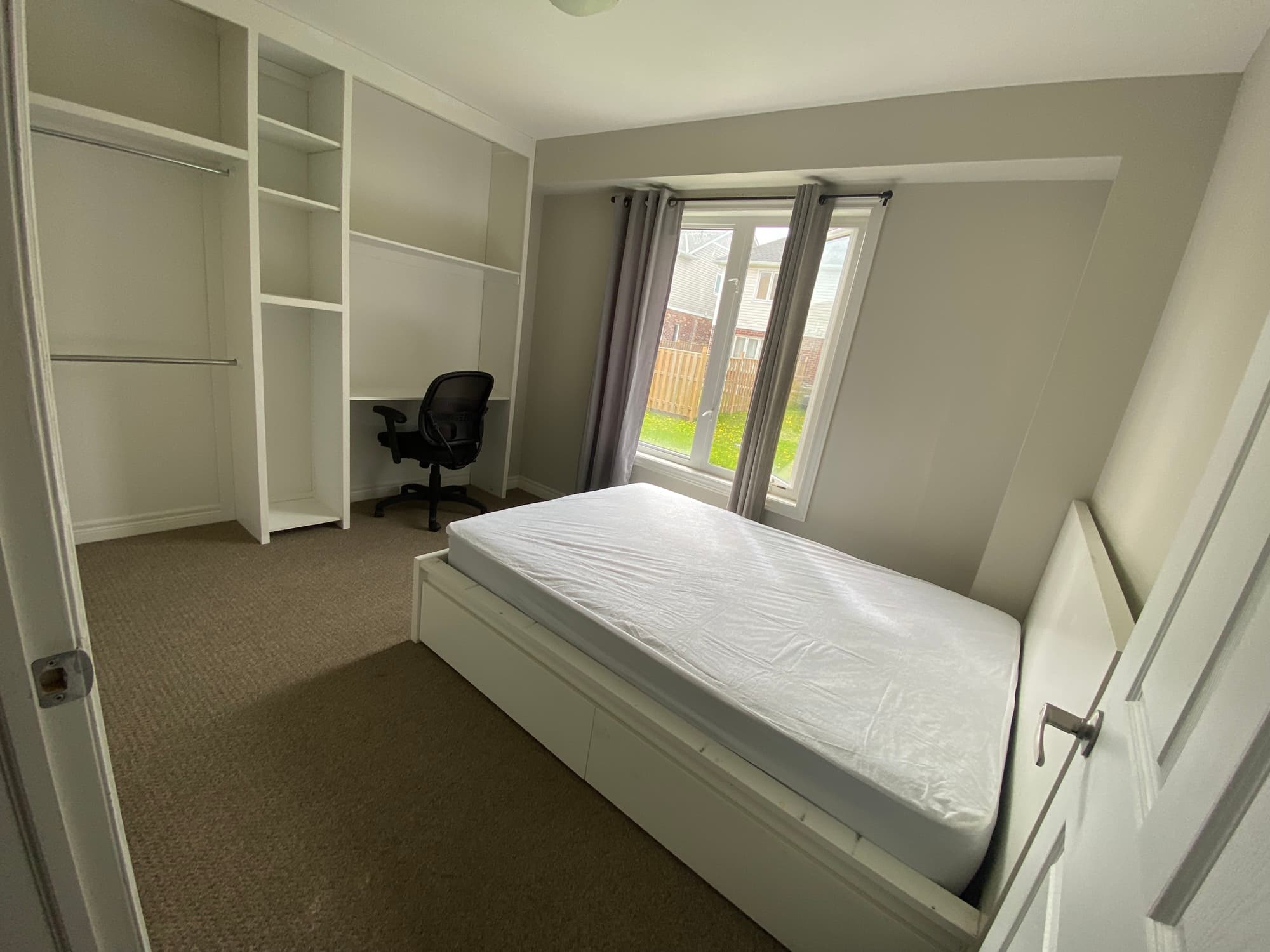 Furnished main-floor bedroom with built-in shelving and desk